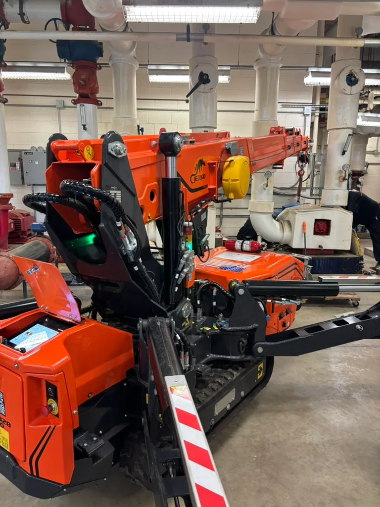 Jekko SPX328 EVO operating in a tight mechanical room among piping and pumps